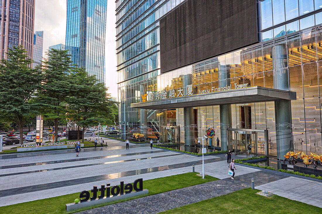 People walk at the entrance gate of the Yuexiu Financial Tower in Zhujiang New Town, central business district of Guangzhou city, China.