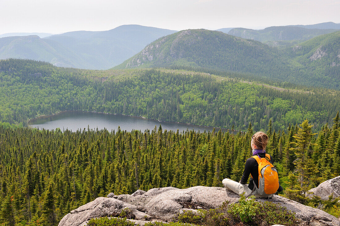 Junge Frau bewundert Landschaft mit Pioui-See, Pioui-Pfad, Grands-Jardins-Nationalpark, Provinz Quebec, Kanada, Nordamerika