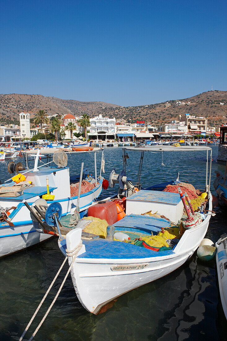 Traditional fishing boats moored in Elounda village harbour. Crete, Greece.