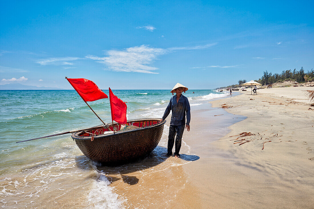 Vietnamese coracle fisherman on Cua Dai beach. Hoi An, Quang Nam Province, Vietnam.