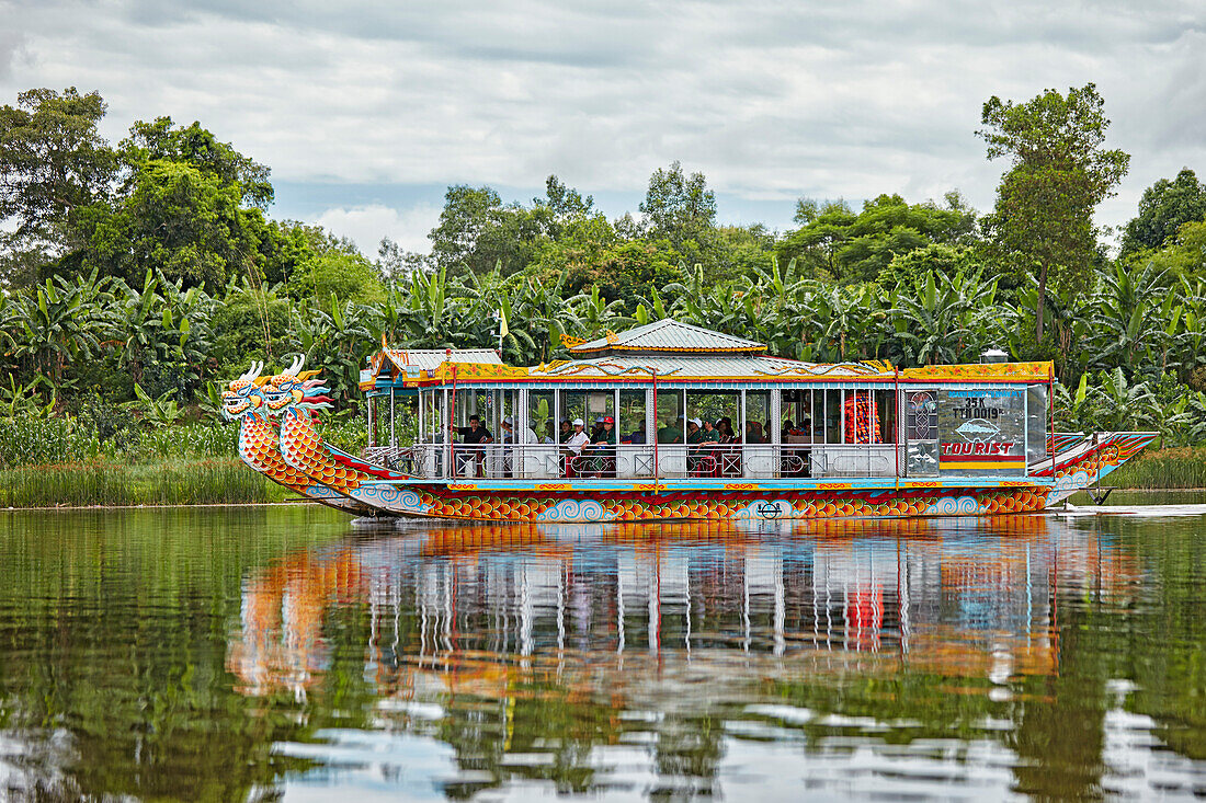 Dragon boat with tourists moves along the Perfume River. Hue, Vietnam.