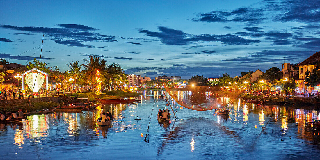 Panoramic view of the Thu Bon River and Hoi An Ancient Town illuminated at dusk. Hoi An, Quang Nam Province, Vietnam.