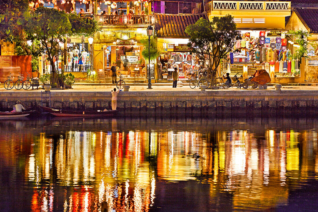 Old houses along the Thu Bon River in Hoi An Ancient Town illuminated at dusk. Hoi An, Quang Nam Province, Vietnam.