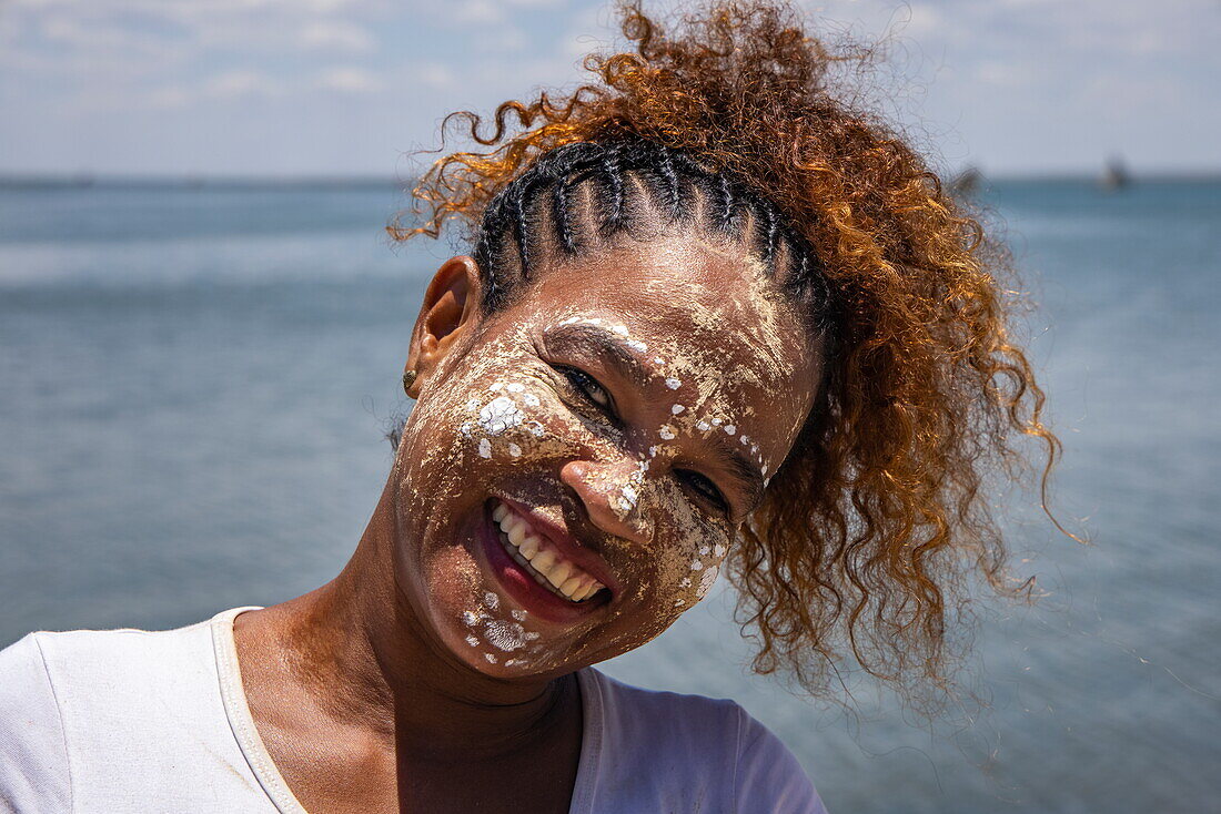 Fröhliche Frau mit Masonjoany-Gesichtsfarbe als Sonnenschutz, Mahajanga, Boeny, Madagaskar, Indischer Ozean