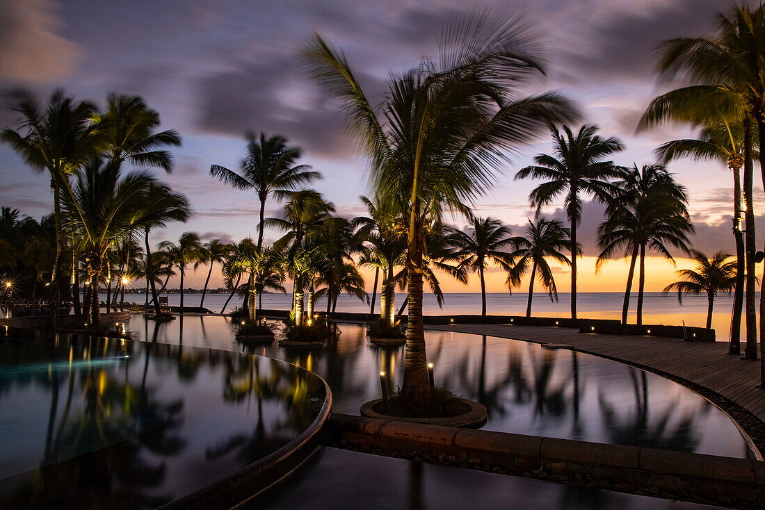 Spiegelung von Kokospalmen im Swimmingpool des Trou aux Biches Beachcomber Golf Resort & Spa bei Sonnenuntergang, Trou aux Biches, Pamplemousses, Mauritius, Indischer Ozean