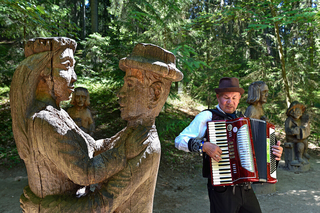 Musiker inmitten von Holzstatuen auf dem Hexenberg, in der Nähe von Juodkrante, Kurische Nehrung, Litauen, Baltikum, Nordeuropa