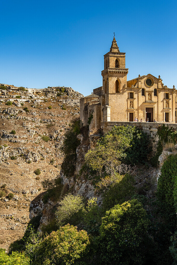 Saint Peter and Saint Paul Church (San Pietro Caveoso) with the Murgia Materana park (Parco della Murgia Materana) in the background, Matera, Basilicata, Italy.