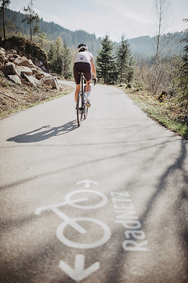 Road biking, woman riding a racing bike on the road