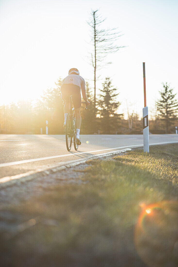 Roadbiken, Frau beim Rennrad fahren auf der Straße