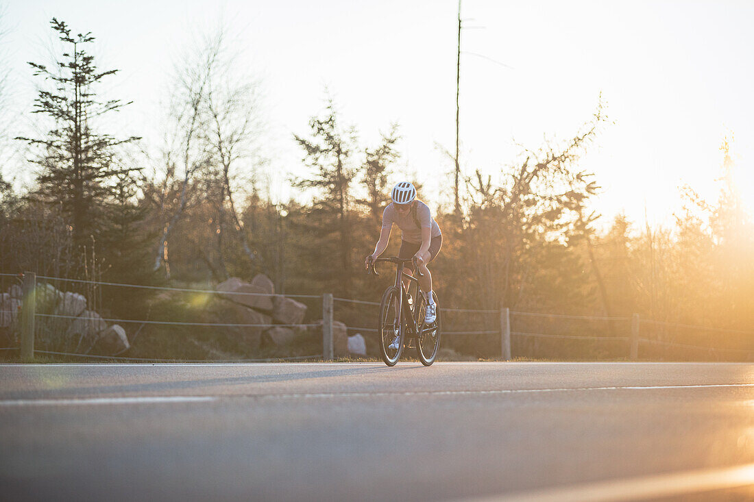 Roadbiken, Frau beim Rennrad fahren auf der Straße