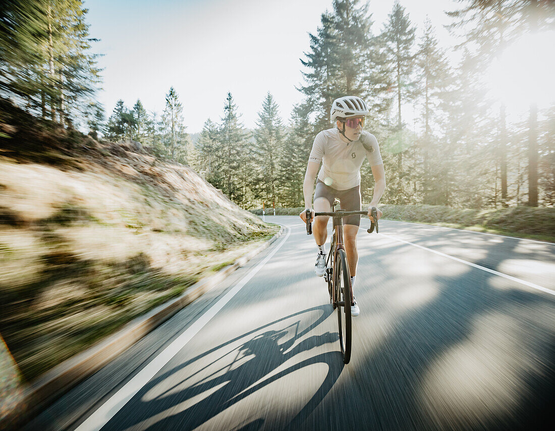 Roadbiken, Frau beim Rennrad fahren auf der Straße