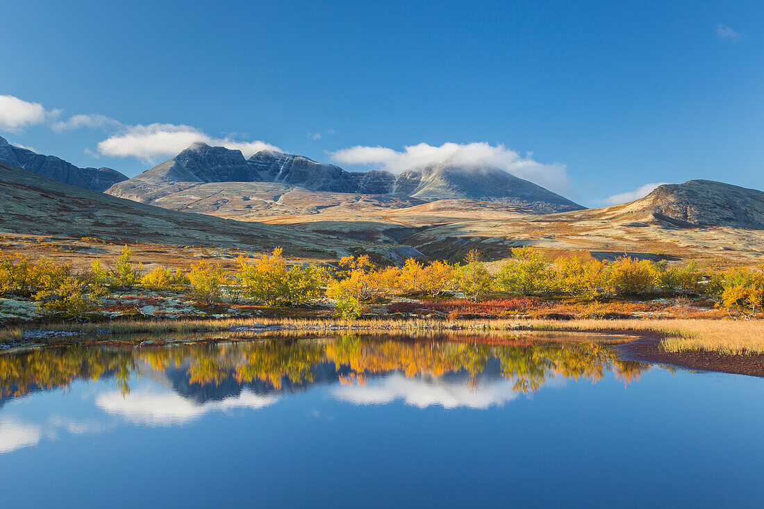  Mountains Høgronden and Digerronden reflected in the lake, Doraldalen, Rondane National Park, Oppland, Norway 