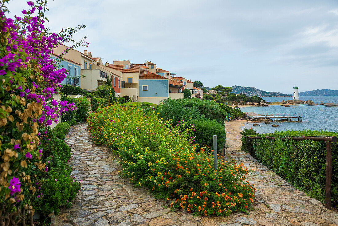  Lighthouse with beach and colorful houses, Spiaggia Porto Faro, Faro di Punta Palau, Palau, Costa Smeralda, Sardinia, Italy 