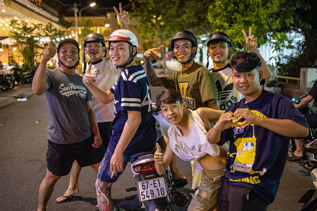 Fröhliche junge Männer posieren nachts auf der Straße, Chau Phong, Tan Chau, An Giang, Vietnam, Asien