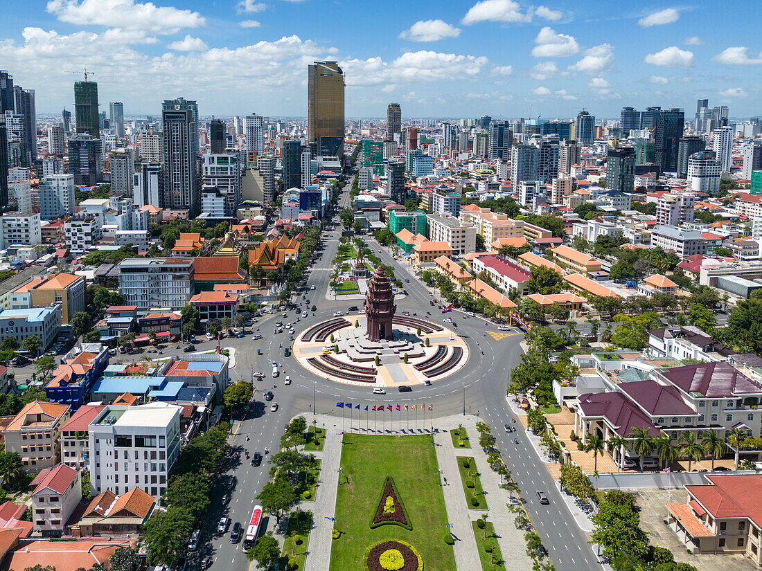 Luftaufnahme des Unabhängigkeitsdenkmals im Stadtzentrum mit Kreisverkehr und Skyline dahinter, Bezirk Chamkarmon, Phnom Penh, Kambodscha, Asien