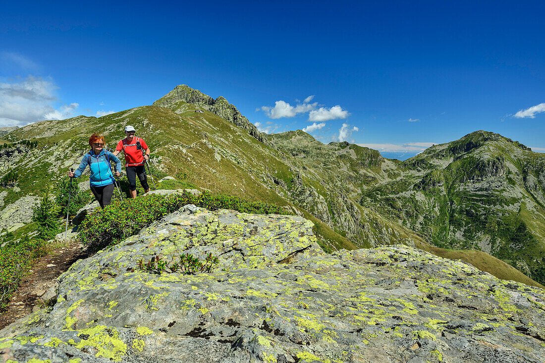  Man and woman hiking over rocky ridge on the GTA with Monte Mars in the background, GTA, Grande Traversée des Alpes, Biella, Alpi Biellesi, Valais Alps, Piedmont, Italy 