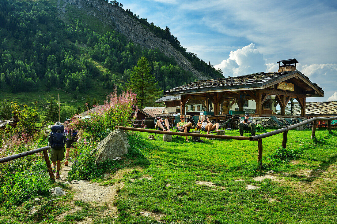  Several people taking a break in the garden in front of the Refuge du Miage, Tour du Mont Blanc, Mont Blanc Group, Graian Alps, Haute-Savoie, Upper Savoy, France 