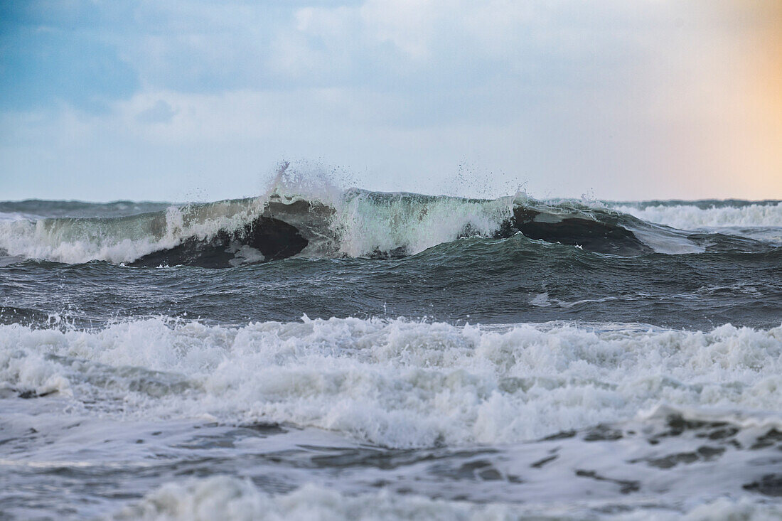 Tosende Brandung am Strand vor Regenbogen, Westfriesische Insel Texel, Nordsee, Provinz Nordholland, Niederlande.