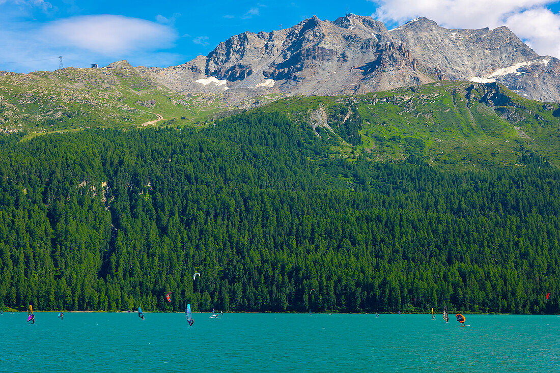 Windsurfing and Wingsurfing on Alpine Lake Silvaplana in a Sunny Summer Day with Mountain in Silvaplana, Maloja, Grisons, Switzerland.