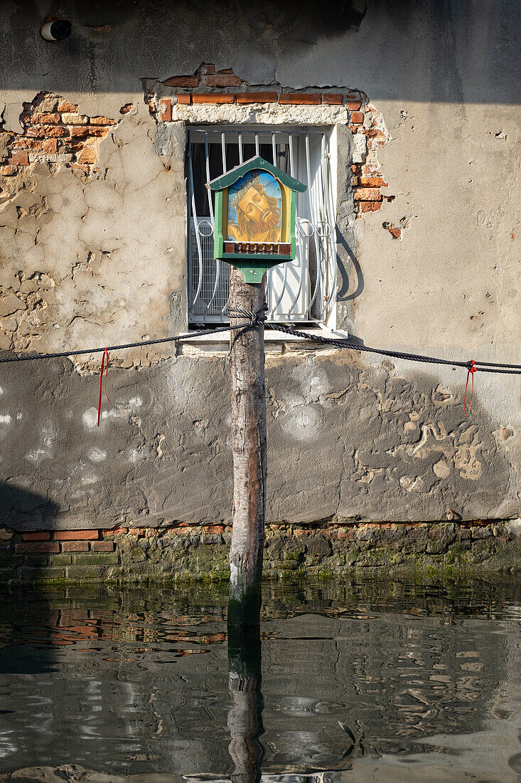  View of a Jesus shrine on a wooden pole in the canal of Chioggia, Chioggia, Veneto, Veneto, Italy, Europe 