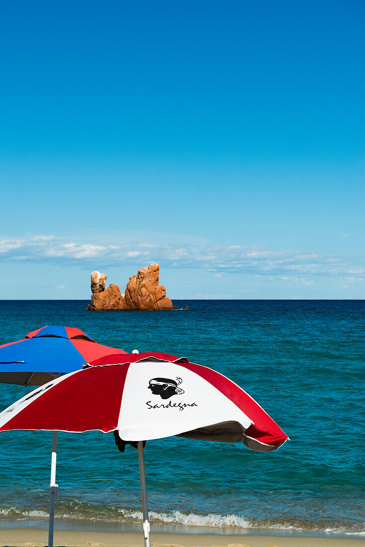  Beach umbrellas and red rocks, Spiaggia di Cea, Tortoli, Sardinia, Italy 