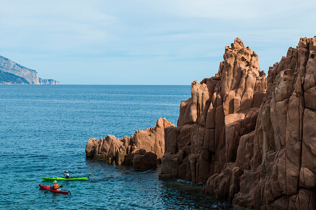  Red rocks by the sea and kayaks, porphyry rocks, Arbatax, Tortolì, Ogliastra Province, Sardinia, Italy 