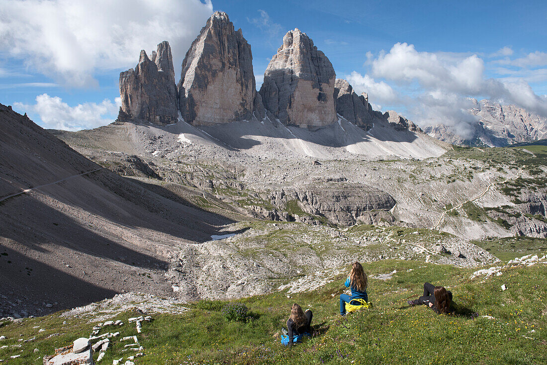 three hikers sitting in front of the Tre Cime di Lavaredo (Three Peaks of Lavaredo), Three Peaks nature park, Trentino-Alto Adige, Sudtyrol, South Tyrol, Italy, South-central Europe