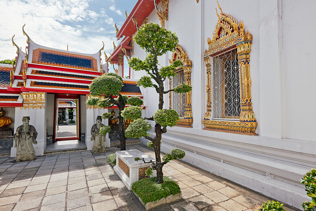 Topiary trees growing in a small courtyard at Wat Pho Temple in Bangkok, Thailand.