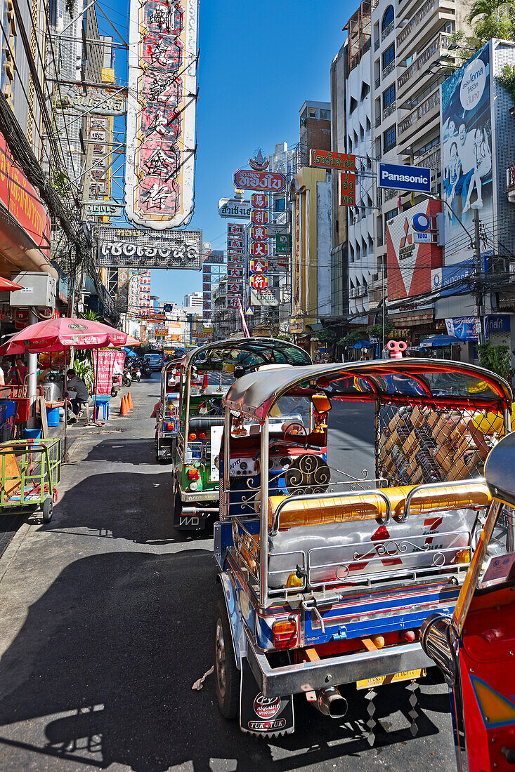 Colorful tuk-tuks waiting for customers on Yaowarat Road. Chinatown District, Bangkok, Thailand.