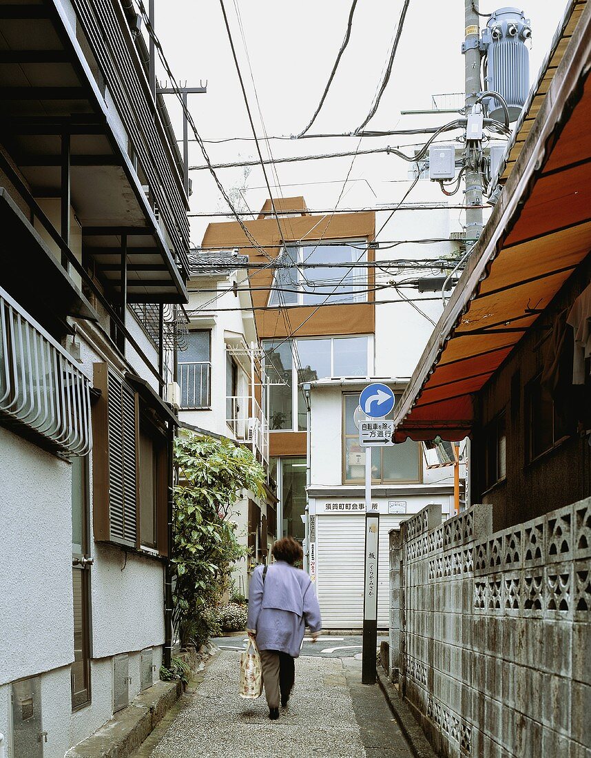 A woman walking down a street in a town