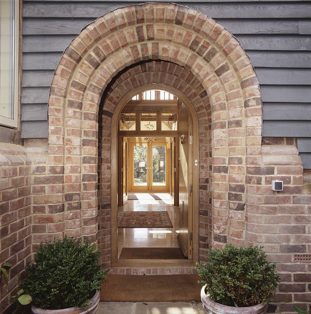 A glazed front door with a brick arch and a view into the hallway
