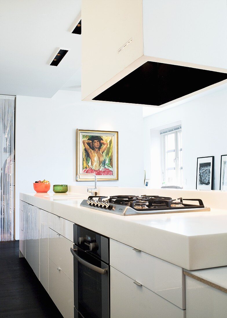 A white kitchen counter with an extractor fan