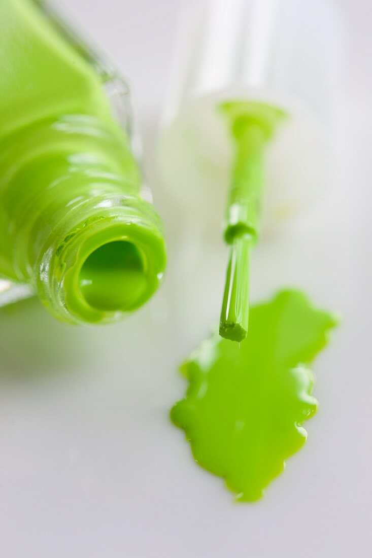 Green nail varnish, an open bottle and a brush