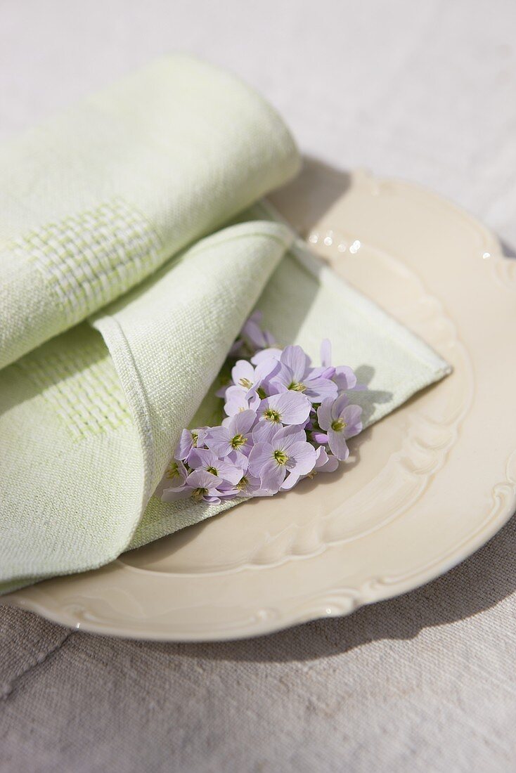 A green napkin and lady's smock on an old plate