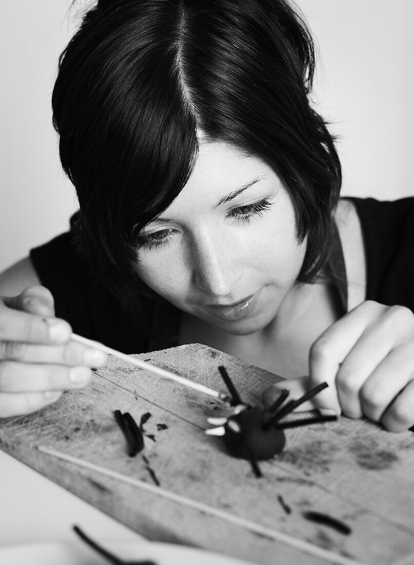 Young woman making spider truffles for Halloween