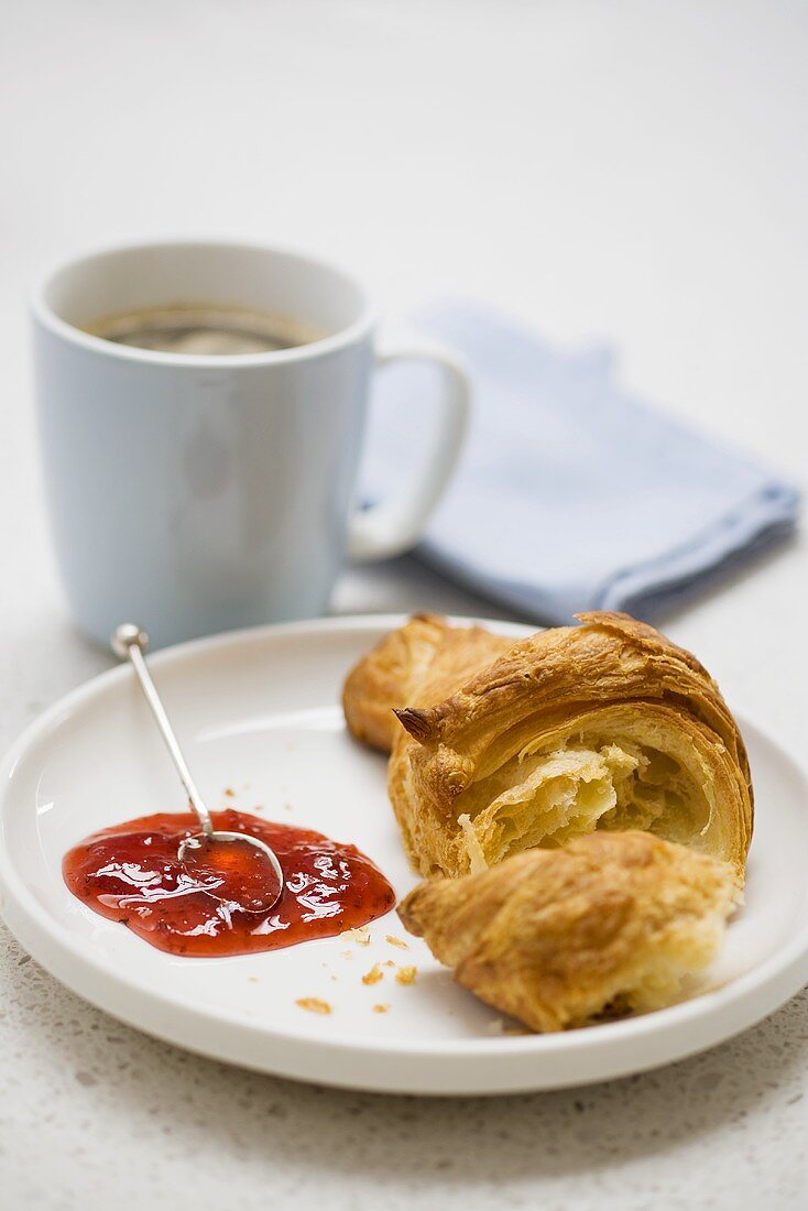 Croissant mit Erdbeermarmelade und Kaffee