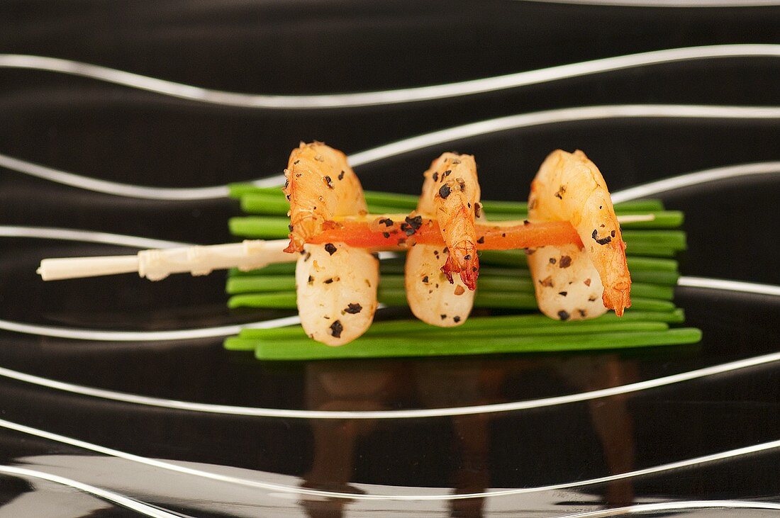 Prawn skewer on fresh chives