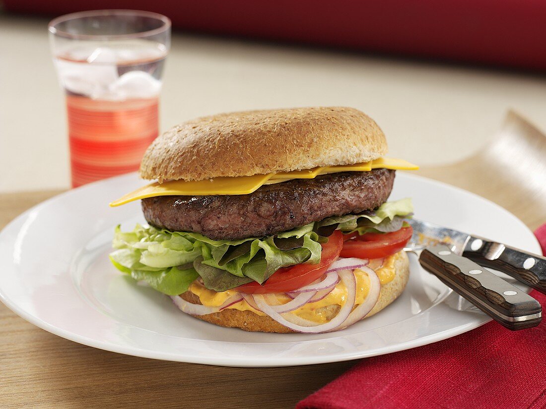 Cheeseburger mit Tomaten, Salat und Zwiebeln