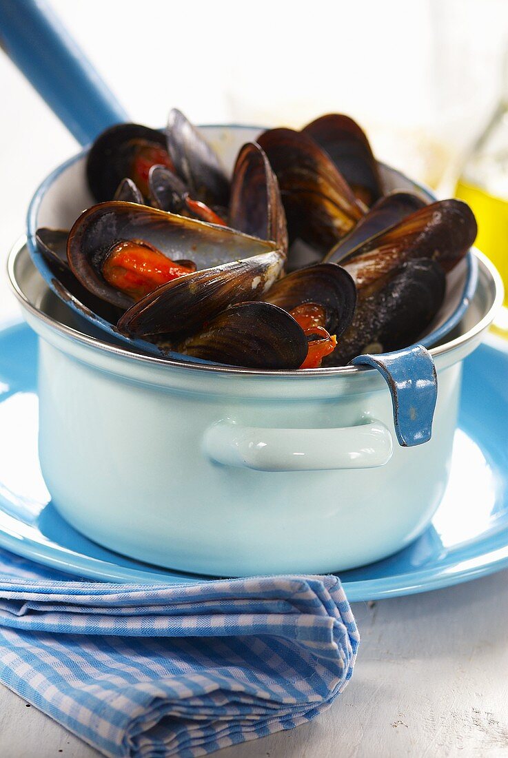 Steamed mussels in a strainer on a pan