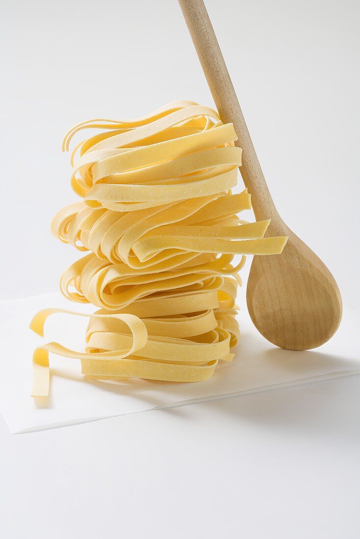 Dried tagliatelle with wooden spoon