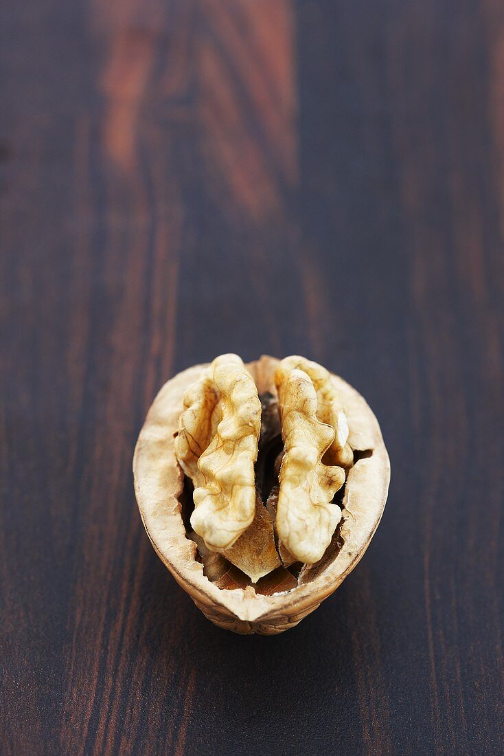 Half a walnut on wooden background