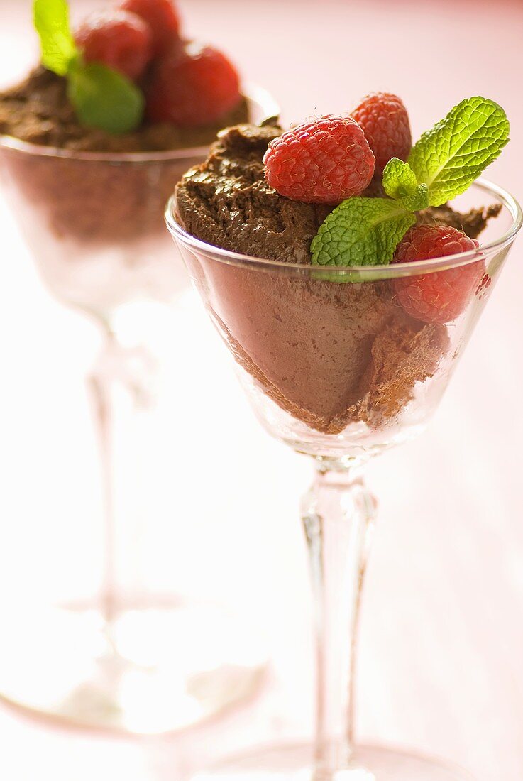 Mousse au chocolat mit Himbeeren und Minze in zwei Gläsern