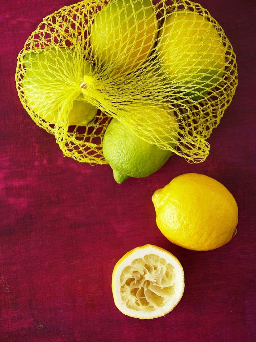 Lemons in net bag, whole lemon and squeezed lemon half