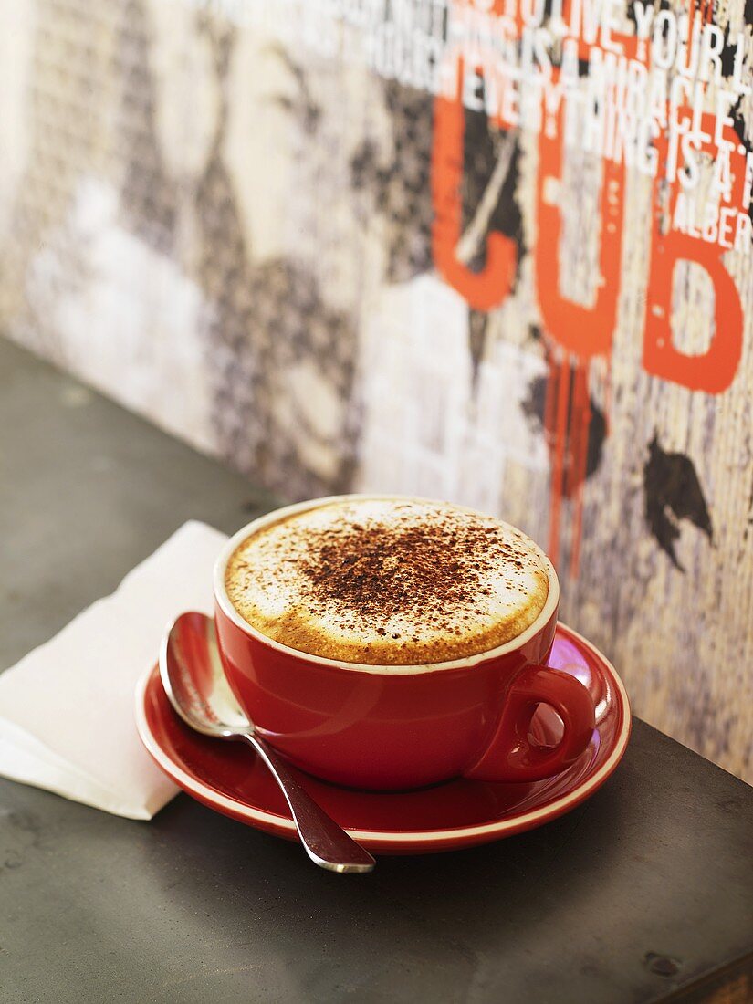 Cappuccino in red cup and saucer