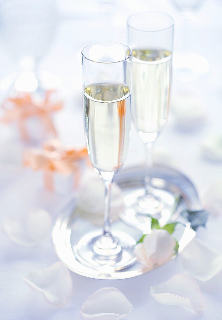 Two champagne glasses on a silver tray