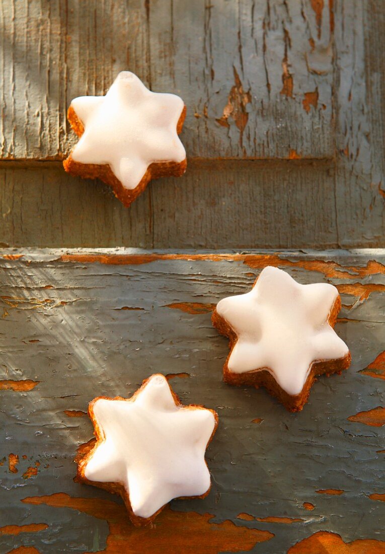Three cinnamon stars on a wooden surface