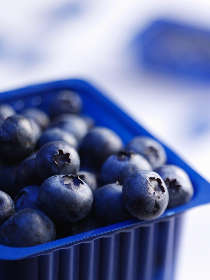 Fresh blueberries in a plastic container (close-up)