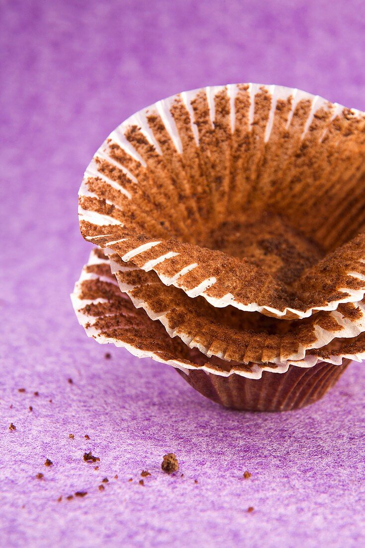 Papierförmchen mit Resten von Schokoladenmuffins