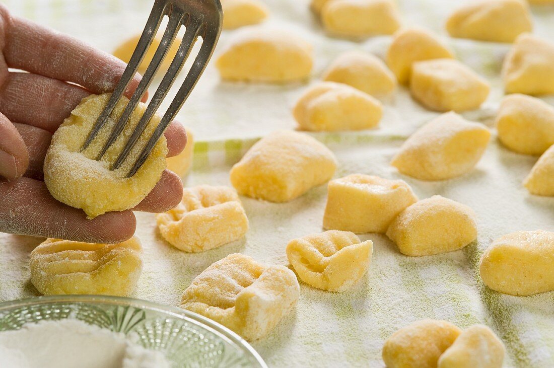 Gnocchi being prepared (being pressed with a fork)