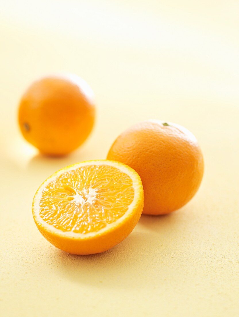 Orangen, ganz und halbiert